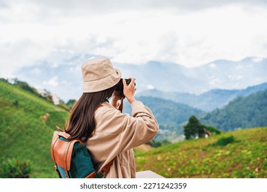 Young woman traveler taking a beautiful landscape at the mountains, Travel lifestyle concept
