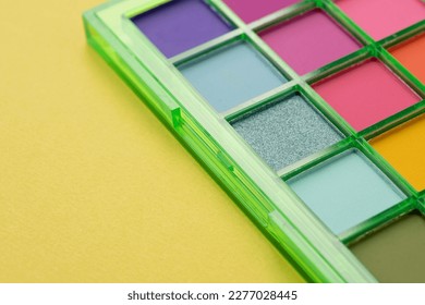 Primer plano de una paleta de sombras de ojos brillantes. Cosméticos de maquillaje. Colores coloridos. Lugar para texto. Disposición plana. Vista superior.