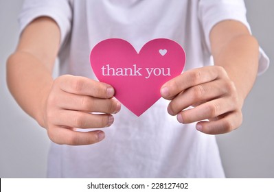 Children holding or showing card with thank you text