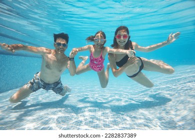 大家庭与小孩在泳池里游泳的水下照片