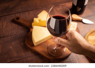 Käseplatte mit einem Glas Rotwein.