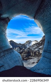 ice cave with a hole overlooking the glacier in the background with moss mountain snow ice at Myrdalsherppur big glacier and ice cave in iceland