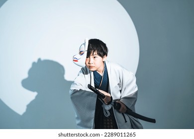 Anak samurai mengenakan kimono. Permainan kostum Jepang.