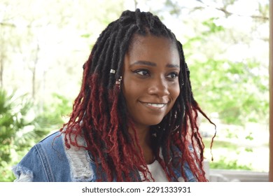 Smiling and beautiful woman of color with ruby red color braided hairstyle