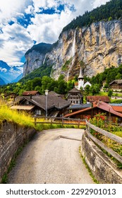 Paisagem de verão incrível da vila alpina turística de Lauterbrunnen com a famosa igreja e a cachoeira Staubbach. Localização: Vila de Lauterbrunnen, Berner Oberland, Suíça, Europa.