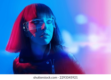 Porträt eines stylischen Cyber-Girls mit leuchtend rotem Make-up und roten Haaren im Neonlicht. Cyberpunk-Konzept. Futuristischer Tech-Stil. VR-Spiele. Freiraum für Text.