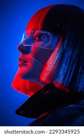 VR-Spiele. Porträt eines stylischen Cyber-Girls mit leuchtend rotem Make-up und roten Haaren im Neonlicht. Cyberpunk-Konzept. Futuristischer Tech-Stil.