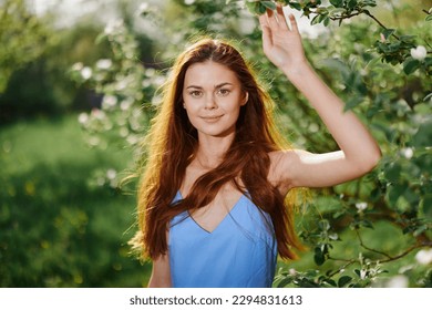 Woman portrait happiness smile with teeth spring in the sun flying hair long red hair, the concept of health and beauty hair sunset
