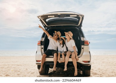 Glücklicher Familientag. Familienurlaub am Meer, Vater, Mutter und Tochter genießen den Roadtrip, sitzen auf dem Rücksitz des Autos und zeigen mit dem Finger nach draußen, Leute haben Spaß im Sommerurlaub am Strand mit dem Auto