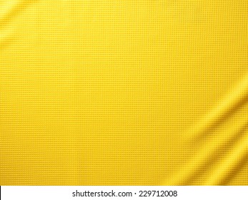 Fondo de textura de tela de ropa deportiva. Vista superior de la superficie textil de tela. Camiseta de fútbol amarilla. Espacio de texto