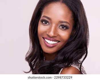 Make-up, gezicht van een gelukkige zwarte vrouw en in studio-achtergrond. Schoonheidsbehandeling, huidverzorging of dermatologie en cosmetica voor zelfzorg met vrouwelijk model met gloed of glans op de achtergrond.