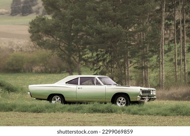 Klassisches amerikanisches Oldtimer-Muscle-Car aus den 1960er - 1970er Jahren auf einer Landstraße an einem sonnigen Sommertag.