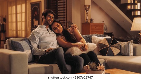 Malam Film: Pasangan Muda Bersantai di Sofa, Menonton Film Menyenangkan di TV. Pacar dan Pacar Berpelukan, Berpelukan, Berbincang, Tersenyum, dan Menonton Layanan Streaming Televisi di Rumah yang Nyaman.