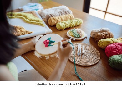 Punch needle. Donna asiatica che realizza lavori a maglia fatti a mano per hobby nel laboratorio dello studio. Luogo di lavoro del designer Progetto artigianale fatto a mano Concetto di ricamo fai da te