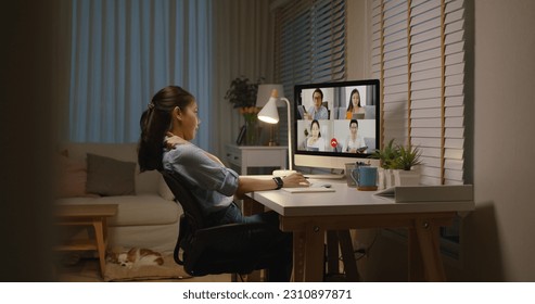 Young asia female busy late night work hard video call online remote group talk stiff neck relief pain ache sit on desk computer in chronic suffer burnout brownout office syndrome workforce at home.