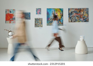 Mișcare neclară a oamenilor care trec prin picturile de pe peretele galeriei de artă