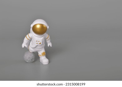 灰色の背景に分離された動作中の宇宙飛行士のおもちゃ。