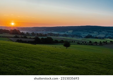 Una mattina presto con un cielo pieno di bellissimi colori durante l'alba nel paesaggio collinare del Limburgo con viste spettacolari sui tipici piccoli villaggi di questa regione