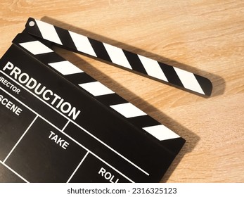 Vue vun engem Klapperbrett op engem hëlzenen Hannergrond. Konzept vu Videoproduktioun, Serien, Filmer, Filmer, Feature Filmer, Filmindustrie.
