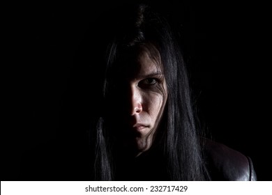 Photo of the brunet man with long hair on black background