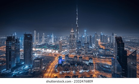 Panorámakép Dubai belvárosának legmagasabb tornyairól és az autópálya éjszakai panorámájáról. Pénzügyi negyed és üzleti terület egy okosvárosban. Felhőkarcoló és toronyházak.
