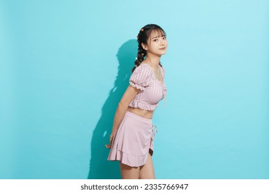 Portrait of young Asian woman in swimsuit on blue background