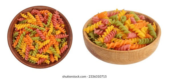 Pasta Fusilli cruda de colores en un cuenco de cerámica aislado sobre fondo blanco con gran profundidad de campo. Vista superior. Plano plano.