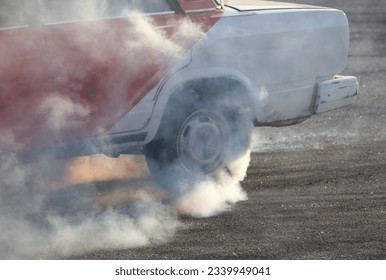 Smoke from under the wheel of a car.