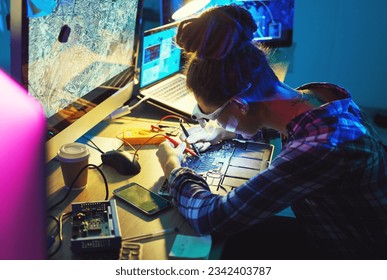 Woman, electronics technician and motherboard with soldering iron for microchip repair. Information technology, circuit board and a person programming for future hardware or system upgrade at night