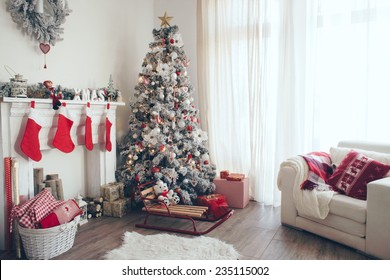 Hermosa habitación decorada con árbol de Navidad con regalos debajo
