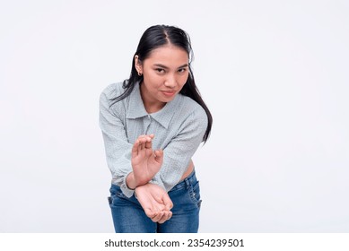A young asian woman makes a playful and whimsical energy blast like an video game character. Isolated on a white background.