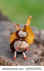 Funny chestnut squirell animal with cute face on natural background stump, traditional fall autumnal handcraft with children