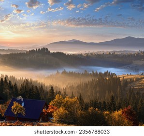 L'aria. Nebbia mattutina e primi raggi di sole sui pendii autunnali dei Monti Carpazi e una fattoria irriconoscibile (Ucraina).