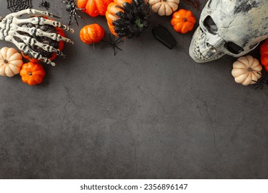 Gruselige Halloween-Grüße: Draufsicht mit thematischem Dekor, Kürbissen, unheimlichen Spinnen, Spinnennetz, Skeletthänden, Totenkopf, kleinem Sarg auf dunkler Grunge-Betonwand, Bereich für Text oder Werbung