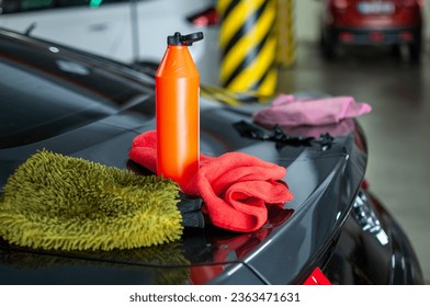 Tools fir en deiere Sportauto an der Garage ze botzen an ze poléieren. Ewechzehuelen opgestoppt schwaarz Sträifen aus Vinyl Wrap.