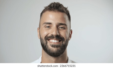 Yakışıklı kişi kameraya yakından bakıyor. Genç yetişkin erkek yüz portresi. İzole edilmiş beyaz arka planda şık 30'lu yaşlardaki adam. Çekici erkek model. Modern milenyum insanları. Vahşi sakallı stil. Berber dükkanı