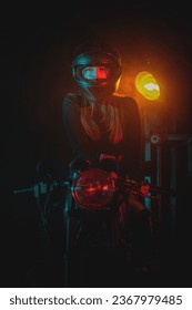 Young beautiful girl in black bodysuit is posing near the motorbike at night street concept. Woman motorbiker.