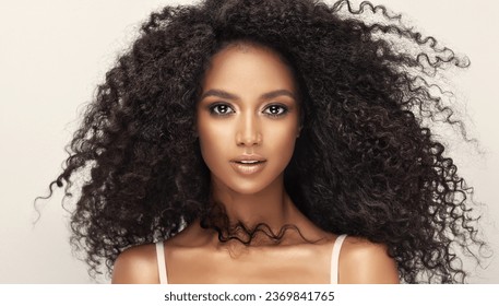 Beauty portrait of african american woman with wavy hairstyle . Smiling dreamy beautiful afro girl.Curly black hair