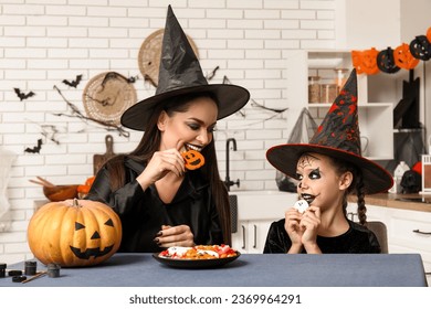 Vajzë e vogël me nënën e saj dhe trajton Halloween në kuzhinë
