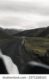 Moss mountains and mud road of Iceland's highlands. Shot from the car's window. Driving off road