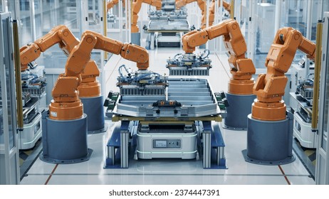 Modern Electric Car Automated Smart Factory. EV Battery Pack Production Line Equipped with Orange Advanced Robot Arms Row of Robotic Arms inside Bright Plant Assemble Batteries for Automotive Industry