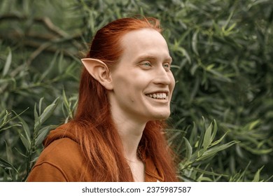 Umělecký elf muž s červenými vlasy a zelenýma očima v lese.