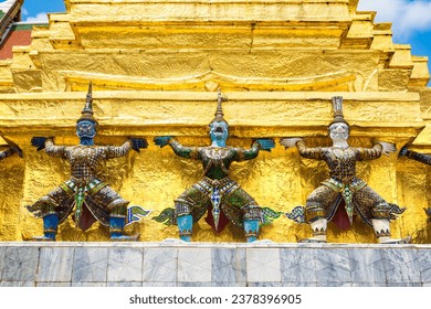 Estátuas de Guardiões Demoníacos sustentam stupa dourada de Chedi no templo Wat Phra Kaew em um dia ensolarado