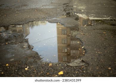 De Puddel um Trëttoir. Naass Strooss. Asphalt Deeler. Pit op der Strooss.