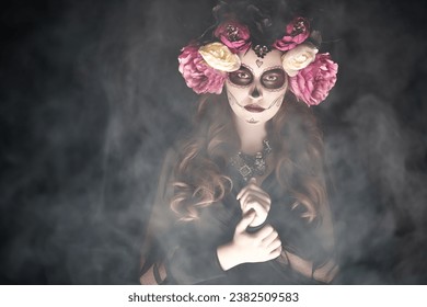 Encantadora y peligrosa Calavera Catrina en una atmósfera mística. Maquillaje y disfraz de chica calavera de azúcar. Día de los muertos. Halloween.