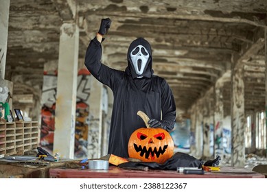 A man with a mask makes a pumpkin