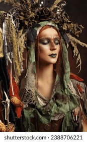 Shaman woman with creative face art fantasy make-up headpiece with floral elements and horns