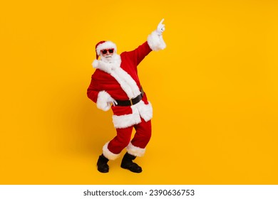 Retrato de perfil de tamaño completo del abuelo santa bailando con el dedo índice en el espacio vacío en la venta de Nochevieja aislado sobre fondo de color amarillo