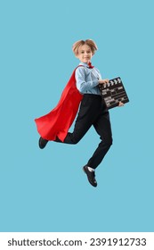 Pequeño actor saltando vestido de superhéroe con aplausos de cine sobre fondo azul