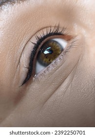 パーマネントアイライナーメイクのクローズアップ。健康で清潔な肌の若い女性
